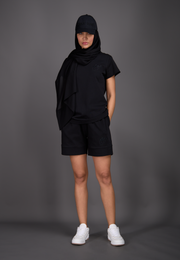 Model wearing black T-shirt and shorts, front view – East Vibe